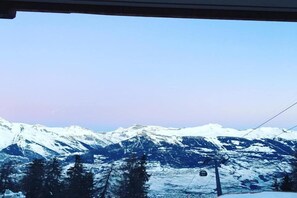 Un paysage de montagne avec des sommets enneigés et un télésiège.