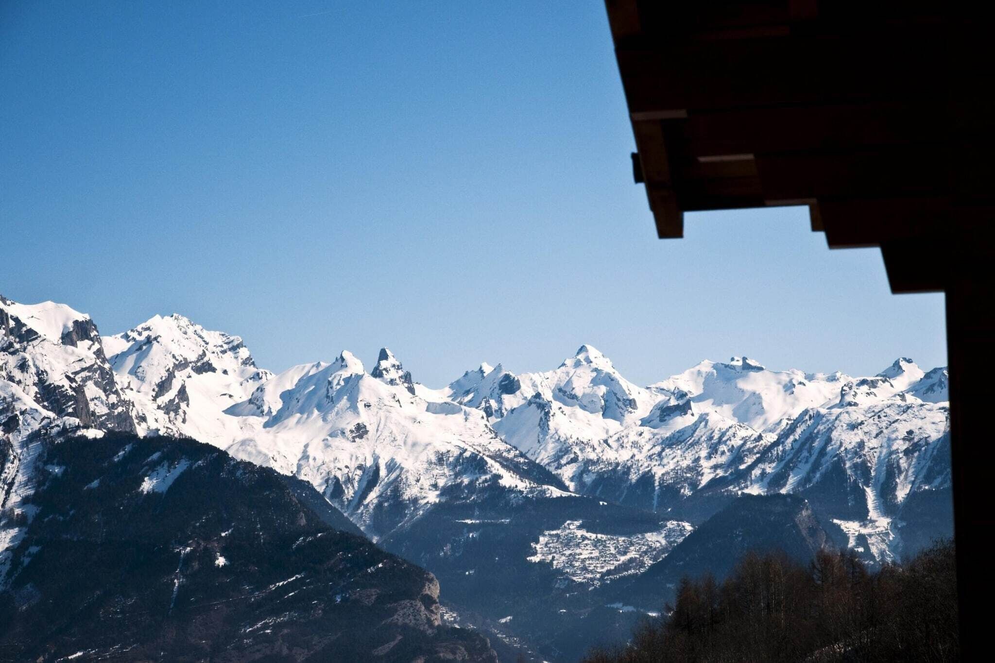 A mountain range with snow-covered peaks and a clear sky.