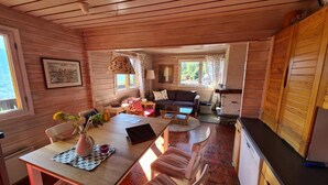 A cozy cabin interior with a dining area, sofa, and kitchen. - Chalet in Vex near Les Masses Chairlift (Vex)