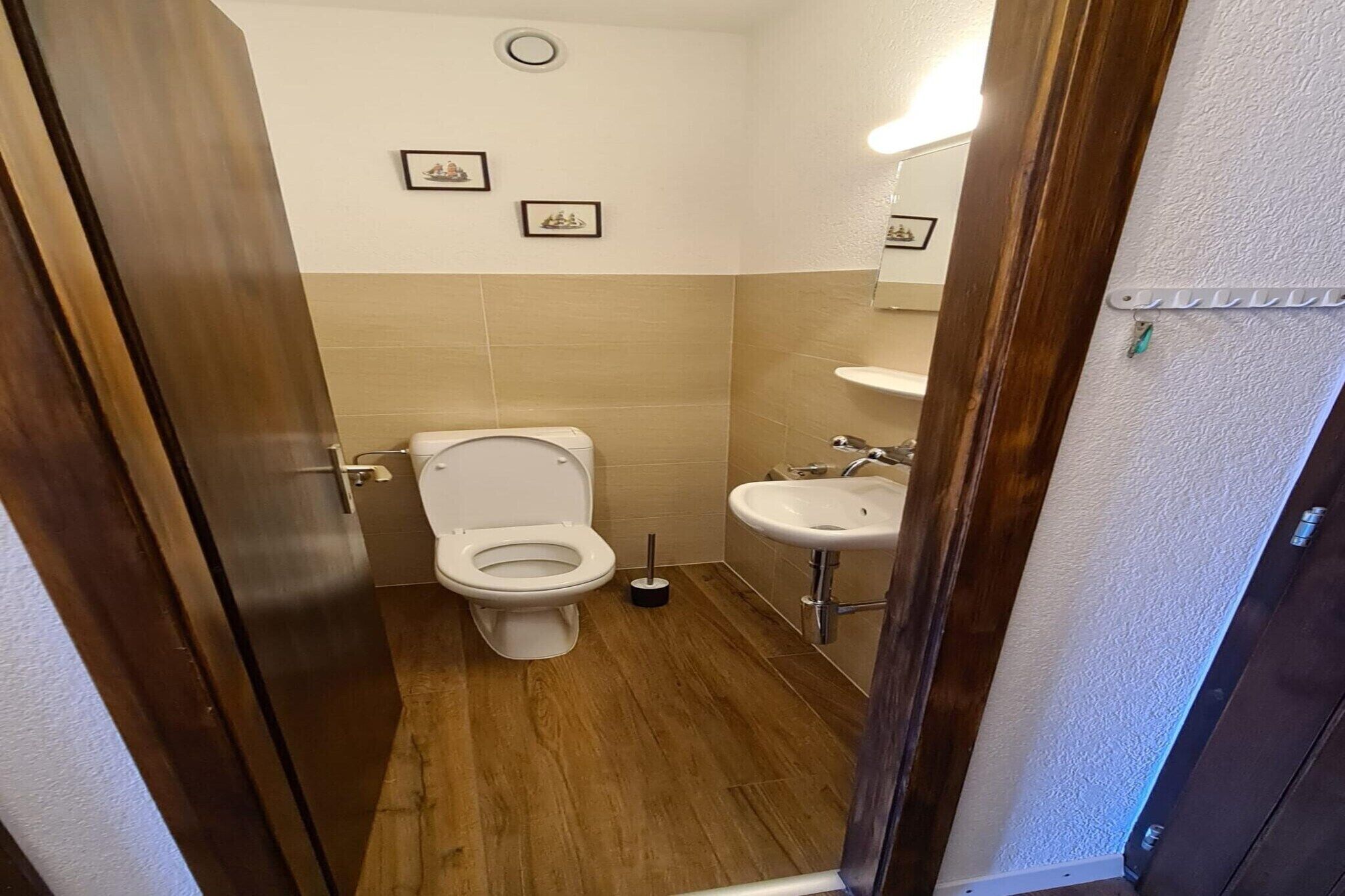 Un baño pequeño con inodoro, lavamanos y espejo.