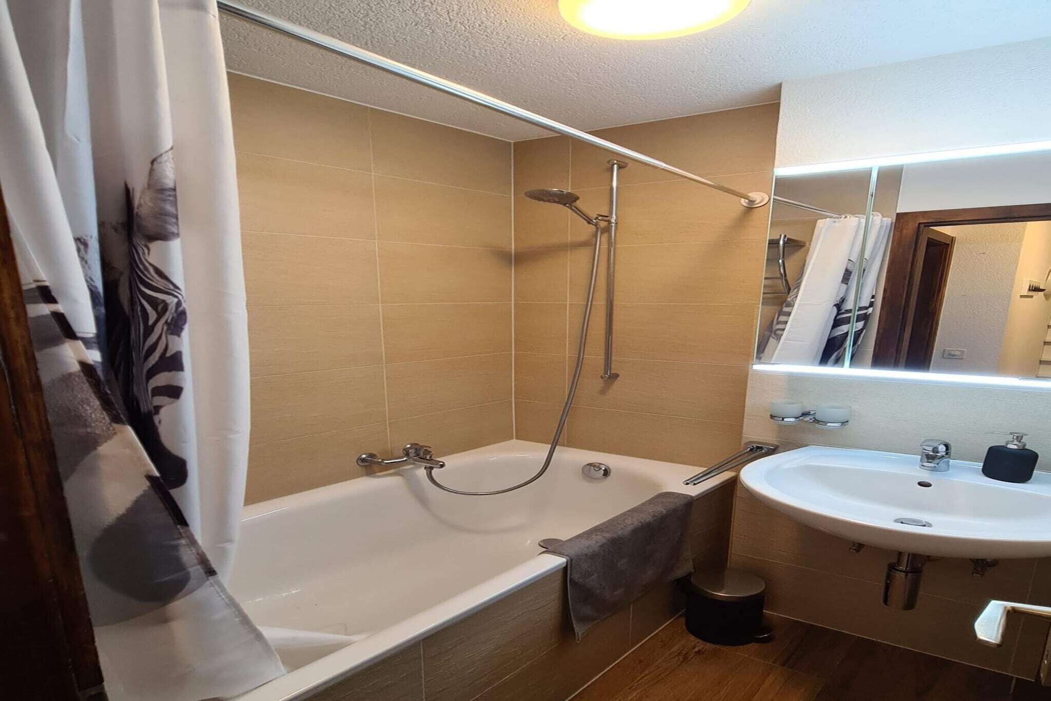 A bathroom with a bathtub, shower, and sink.