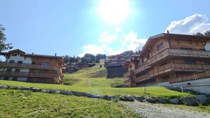 A mountainous village with wooden buildings, a clear sky, and a sunny day.