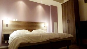 A bedroom with a large bed, a wooden headboard, a wardrobe, and a bedside table with a lamp. - Elegant Stay at Château Spa (Ferrassières)