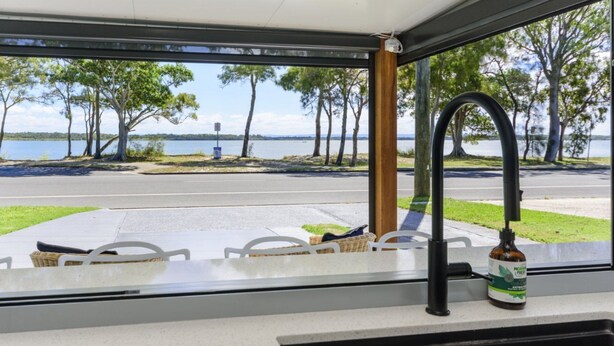 A kitchen with a view of a lake and trees.