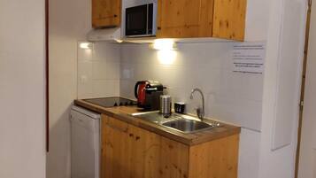 Een koelkast, een magnetron, een kookplaat, een vaatwasser