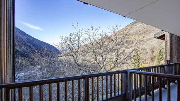 Ein Balkon mit Blick auf eine gebirgige Landschaft.