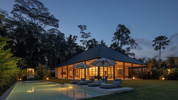 A modern house with a swimming pool, outdoor seating, and a covered patio area.