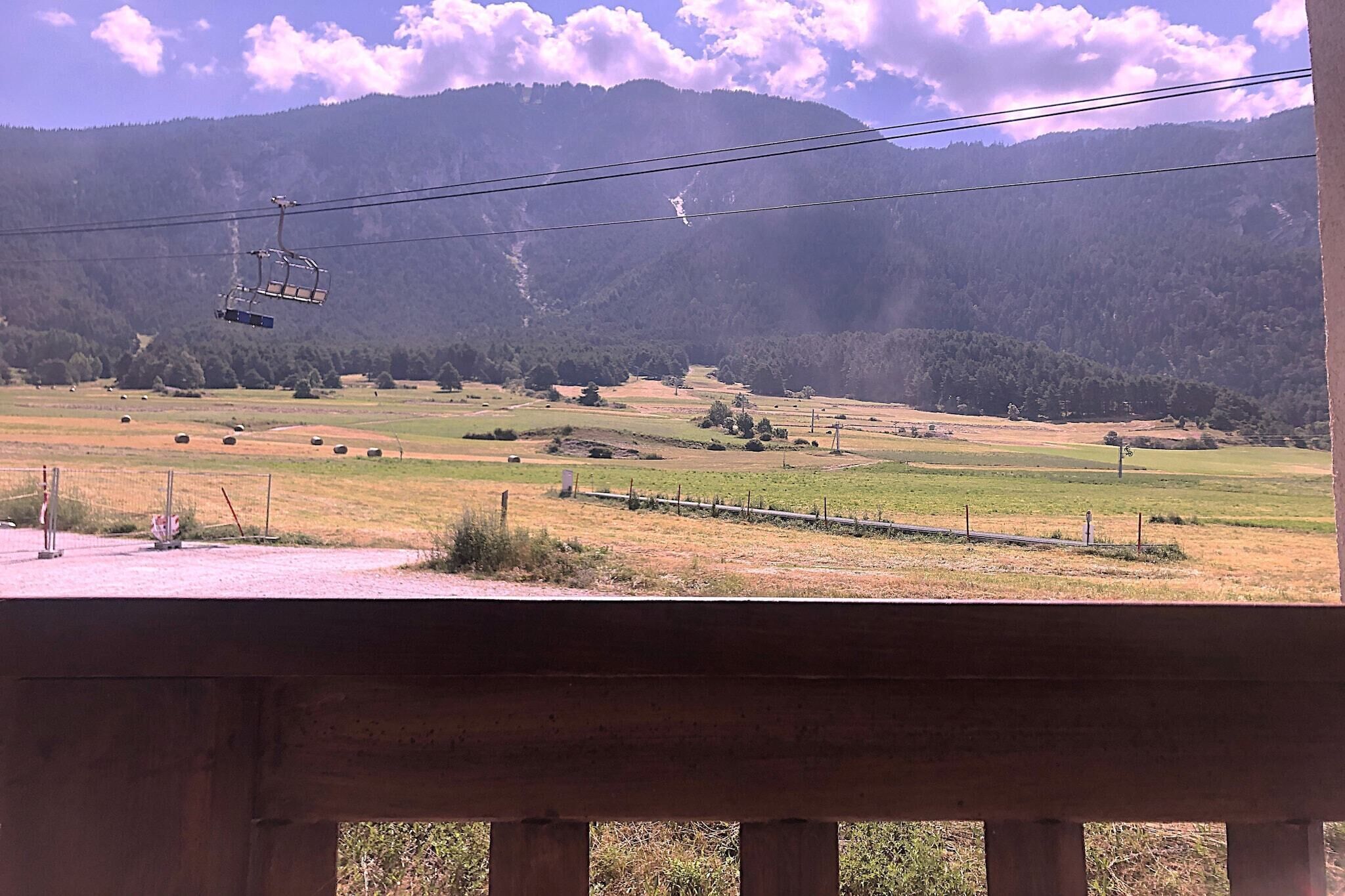A scenic view of a mountainous landscape with a cable car in the distance.
