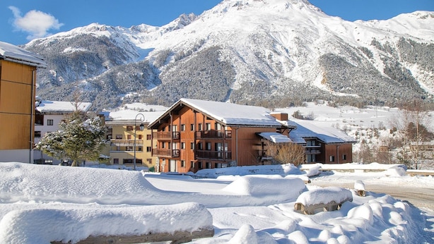 A snow-covered mountain with a wooden building in the foreground. - Apartment with 2 rooms, balcony (Val Cenis)