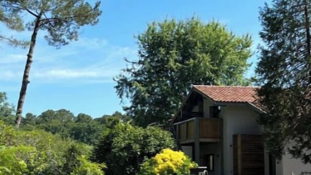 A building with a tiled roof, surrounded by lush greenery and trees. - Laguillotte- 3 bedrooms (Seignosse)