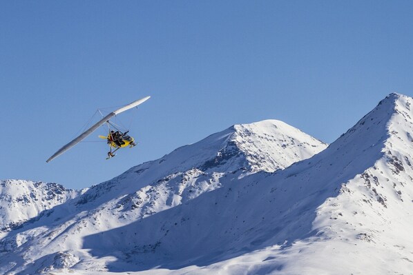 Un helicóptero volando sobre una montaña nevada.