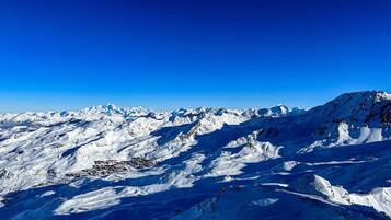 A snow-covered mountain range with a clear blue sky.