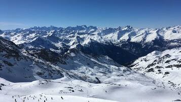 A snow-covered mountain landscape with skiers.