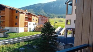 A view of a building with a ski resort sign, a stone pathway, and a mountain in the background. - Apartment for 6 people in Val Cenis (Val Cenis)