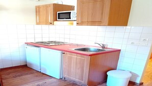 A compact kitchen with wooden cabinets, a microwave, a sink, and a dishwasher. - Apartment for 6 people in Val Cenis (Val Cenis)
