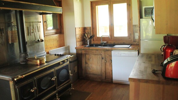 A kitchen with wooden cabinets, a sink, a stove, and a dishwasher.