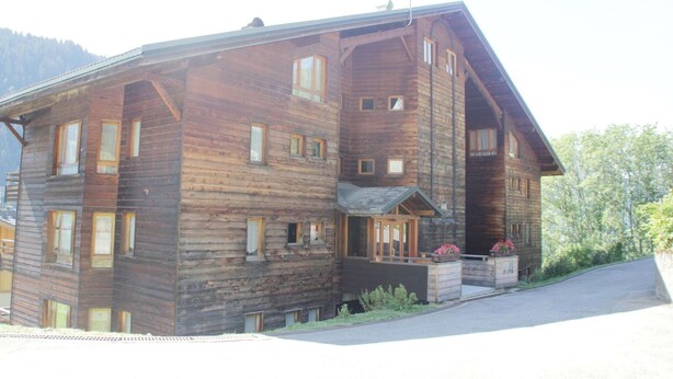 A large wooden building with multiple windows and a porch area. - Val Pierre apartment for 8 people (Châtel)