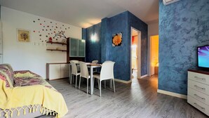 Een modern appartement met een eethoek, een bed en een televisie.