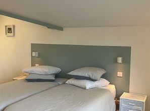 A bedroom with two beds, each with multiple pillows and a headboard. There are bedside lamps and a small bedside table. - Laguillotte - Double room-Twin  (Seignosse)