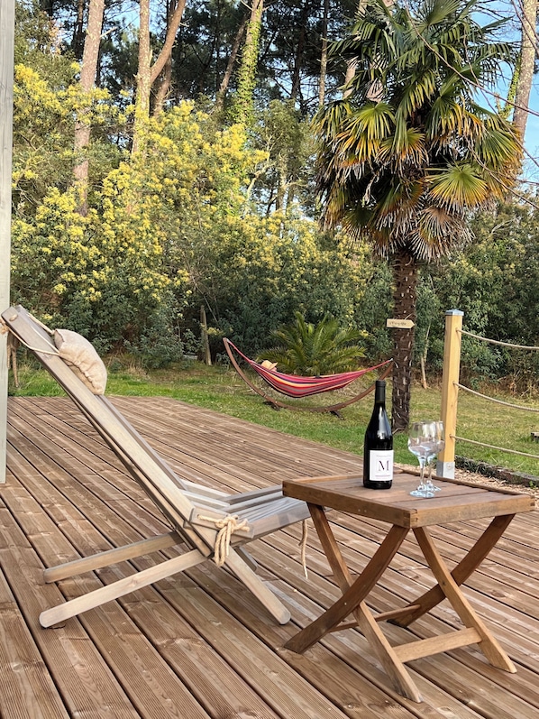 A wooden deck with a hammock, a bottle of wine, and a glass on a small table. - Laguillotte - Double room-Twin  (Seignosse)