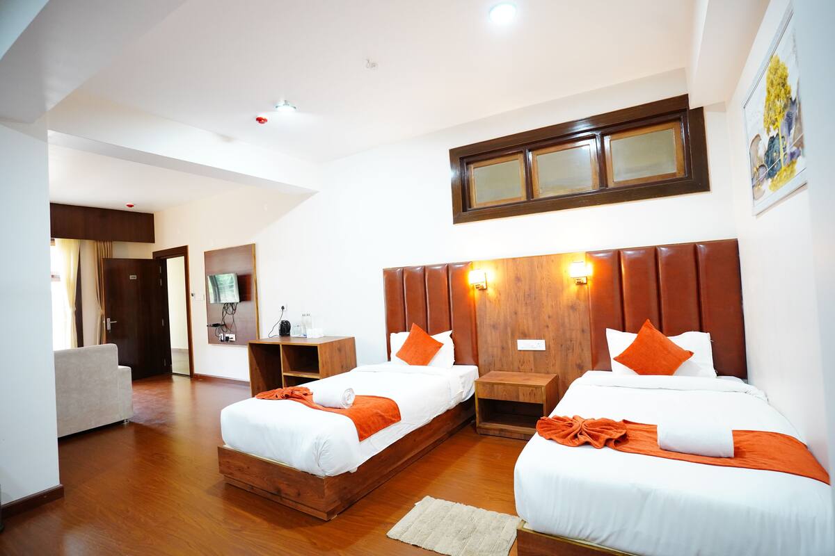 A hotel room with two beds, wooden headboards, and a large mirror above the beds.