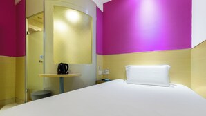 A hotel room with a bed, a small bedside table, a mirror, and a door to the bathroom. - YIbaihotel (Shanghai)