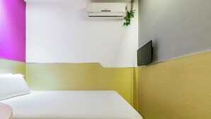 A hotel room with a bed, a bedside table, a TV mounted on the wall, and an air conditioning unit. - YIbaihotel (Shanghai)