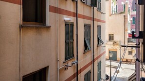 Eine enge Straße mit Gebäuden, die traditionelle Fensterläden und eine sichtbare Straßenlaterne zeigen.