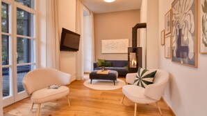 A modern living room with a sofa, two armchairs, a coffee table, and a fireplace.