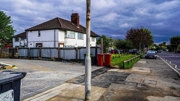 A residential street with houses, a sidewalk, and parked cars. - Modern 4-Bedroom Home with Free Parking (Slough)
