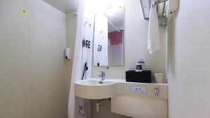 Une petite salle de bain avec un lavabo, un miroir et des toilettes.
