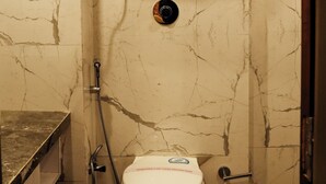 A bathroom with a toilet, a shower, and a water heater. - hotel sainison manali (Manali)