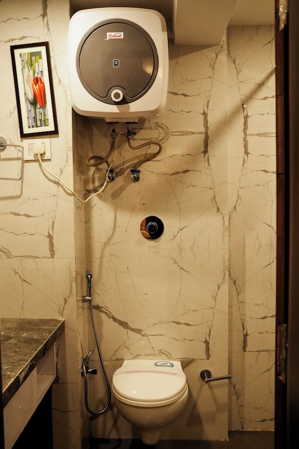 Un bagno con il water, una doccia e uno scaldabagno.