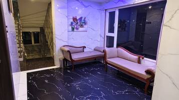 A modern interior with a marble floor, a sofa, and a window with a view.