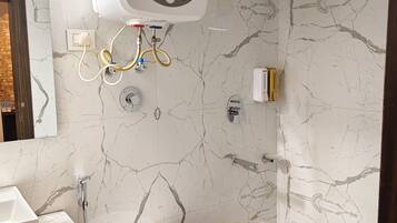 Ein Badezimmer mit Toilette, Waschbecken, Dusche und Warmwasserbereiter.