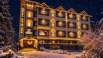 A multi-story hotel with a prominent sign, multiple windows, and a snow-covered entrance.