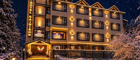 A multi-story hotel with a prominent sign, multiple windows, and a snow-covered entrance.