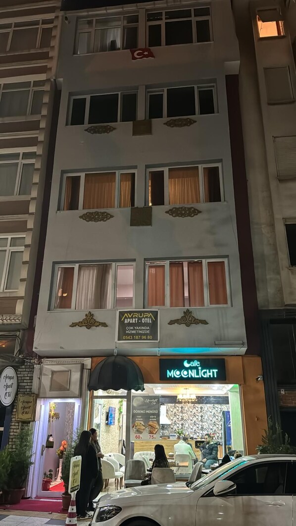 Een meerlaags gebouw met een café genaamd 'Moonlight' op de begane grond.