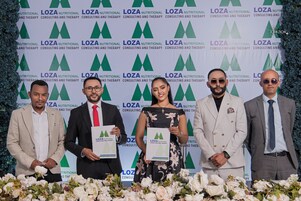 Um grupo de pessoas em frente a um painel com o logotipo da LOZA.