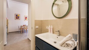 A bathroom with a large mirror, a sink, and a towel. - Carignano Sweet Home by Wonderful Italy (Genoa)