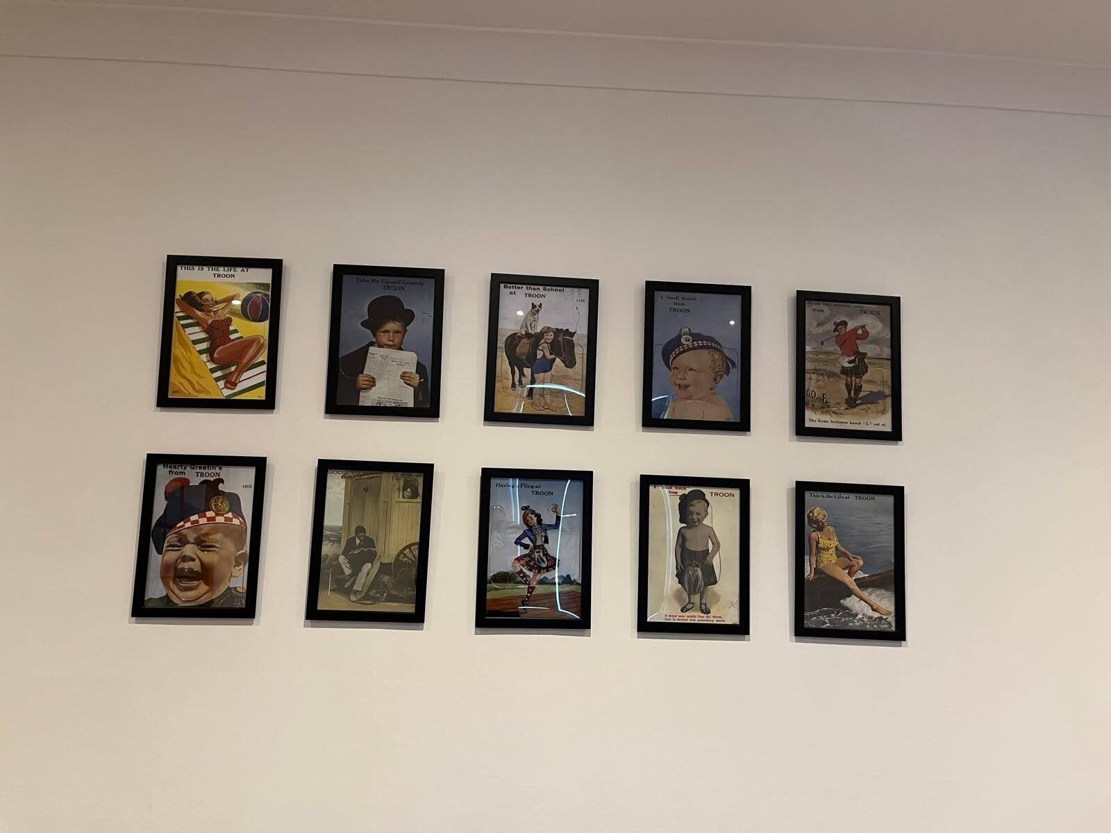 Een muur met negen ingekaderde foto's, die elk verschillende taferelen en onderwerpen weergeven.