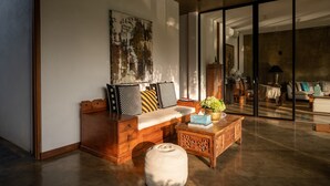 A modern living room with a wooden sofa, a coffee table, and a large abstract painting on the wall. - Villa Tranquil Waters (Negombo)