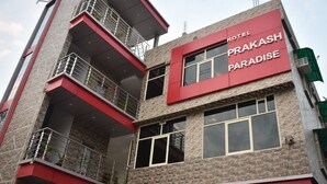 Un hotel de varios pisos con una fachada destacada en rojo y gris, balcones y ventanas amplias.