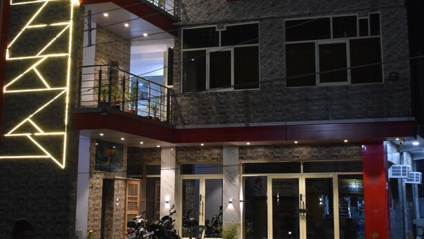 Un edificio de varios pisos con un letrero que dice "Hotel Prakash Paradise".