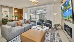 Een moderne woonkamer met een hoekbank, fauteuils, een salontafel en een open haard.