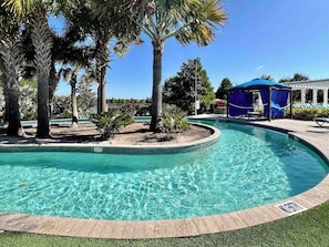 A clear swimming pool surrounded by palm trees and a covered seating area. - Lake View! Big Screen! Resort 6 mi 2 Disney-8866 (Kissimmee)