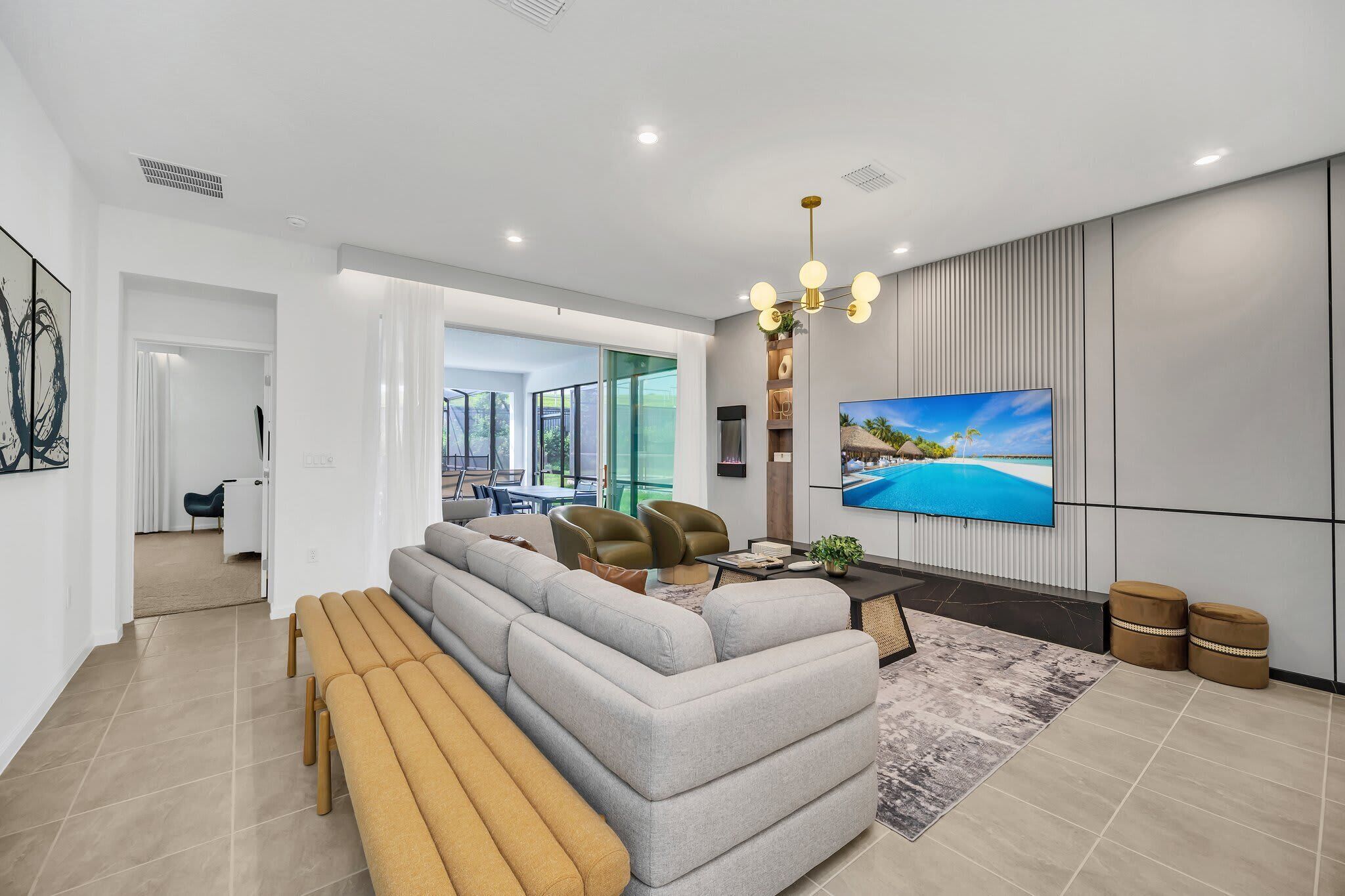 A modern living room with a sectional sofa, a coffee table, and a TV mounted on the wall.