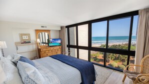 Une chambre dotée d’une grande fenêtre donnant sur la plage et l’océan.