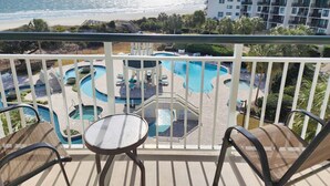 A balcony with a view of a beach and a pool area. - Oceanfront w/ Lazy River! Rare floorplan, Nicely Furnished, 2BRs-Bridgewater 507 (Pawleys Island)