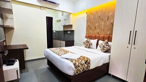 Ein Hotelzimmer mit Bett, Schreibtisch, Kleiderschrank und Spiegel.
